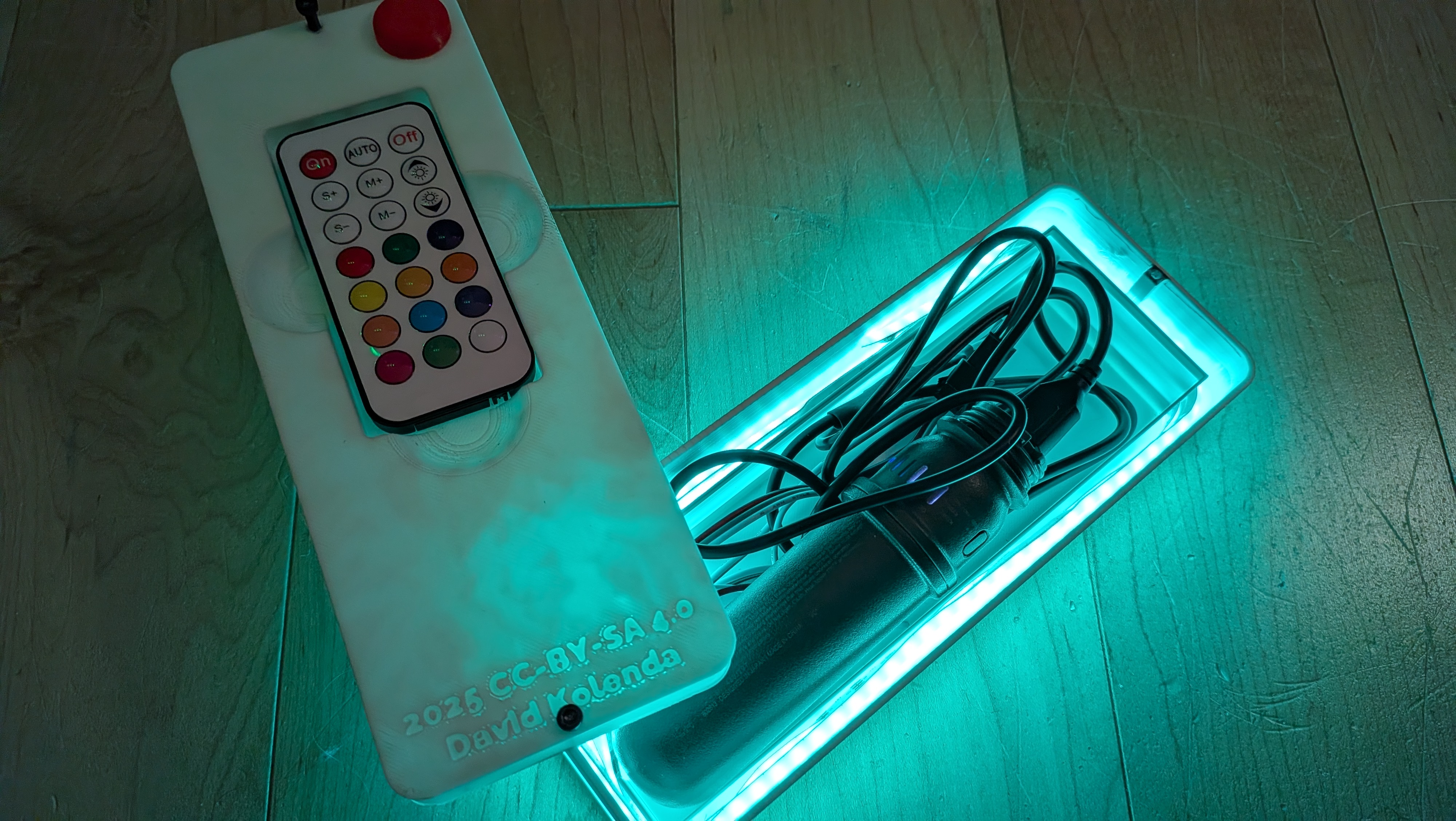 The light-up remote opened, showing wires and a small, cylindrical battery