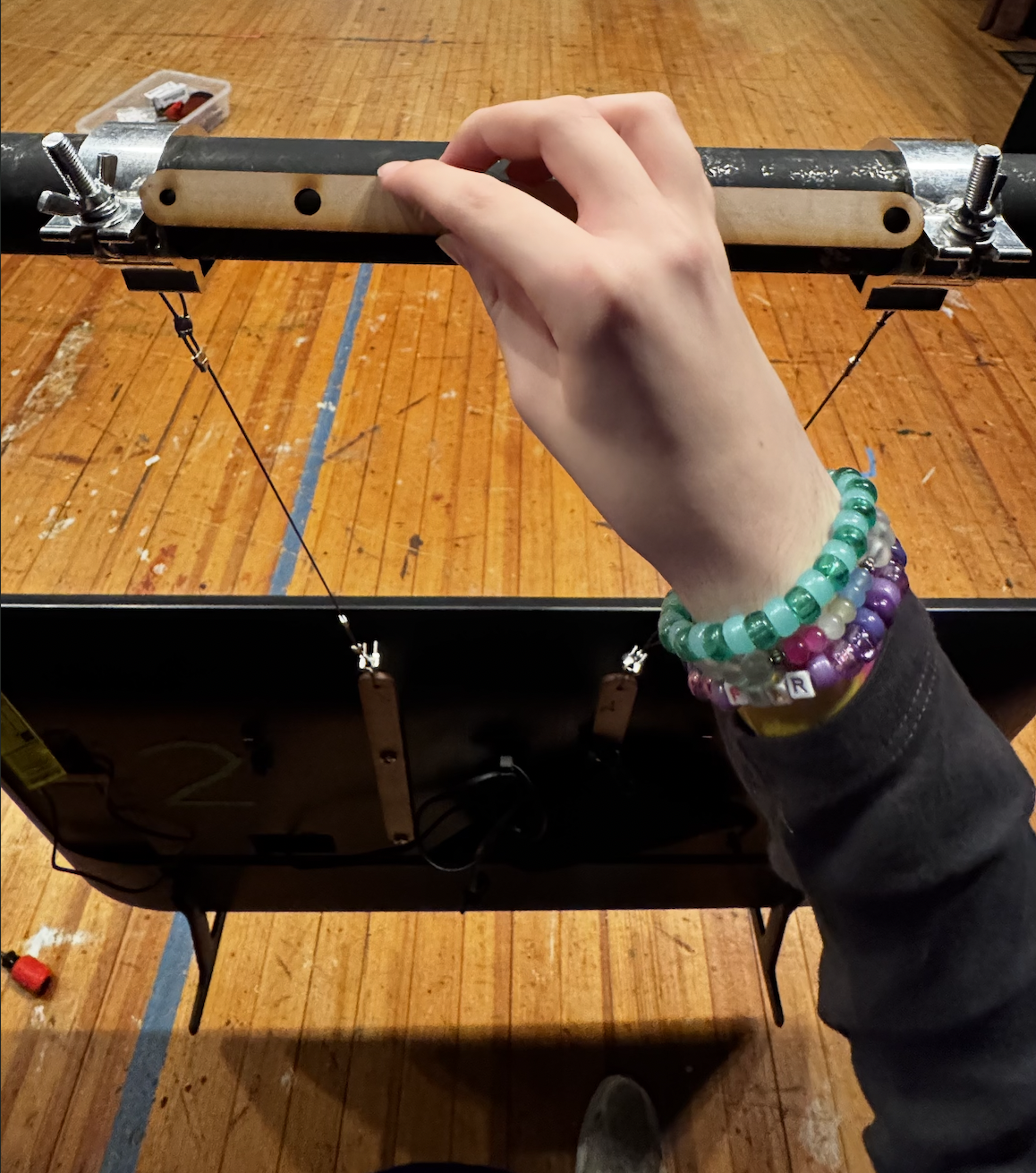 A TV being flown with the use of laser-cut VESA adapters, aircraft cable, and light o-clamps