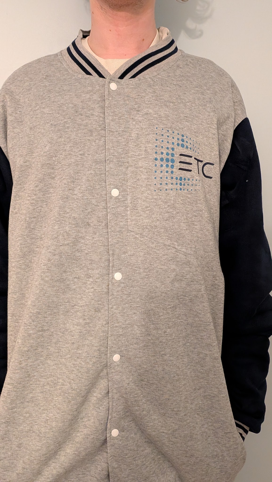 The front of a varisty jacket. The ETC logo is sublimated over the right chest.
